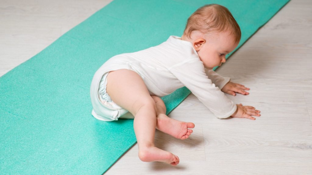 Baby tries to crawl off yoga mat