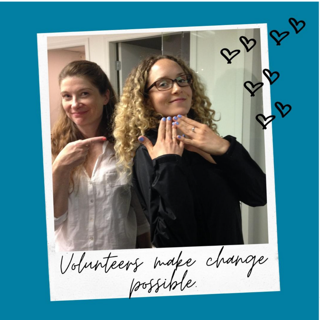Polaroid picture of two women with light skin and long hair showing off their nails. Text reads: Volunteers make change possible.